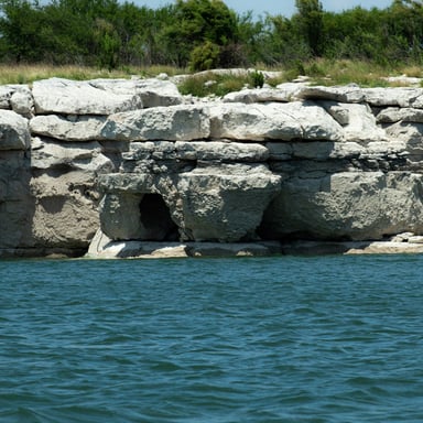 Rock cavern entrance at the water's edge